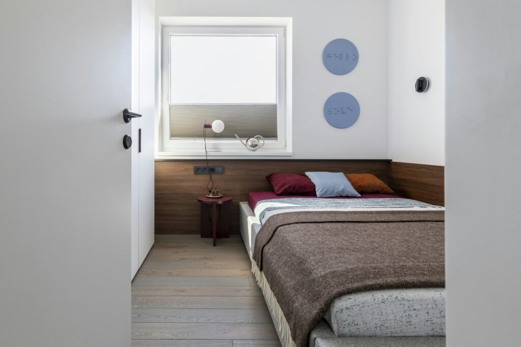 Cosy modern bedroom with a single bed, window and blue decor, showing how a small room can feel