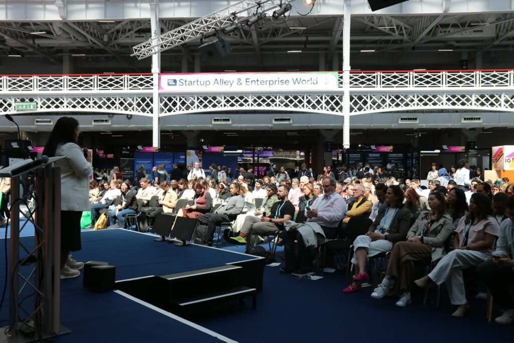 A speaker addressing an audience at an indoor conference event