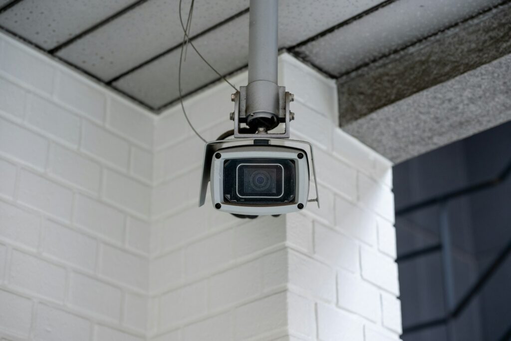 Security camera mounted on a white brick wall, showing a typical position for home CCTV