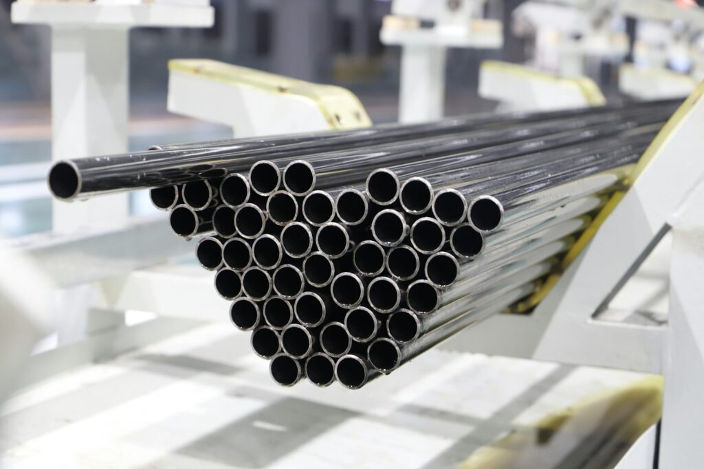 Stack of metal pipes on a factory line, the kind of steel pipework that benefits from lining
