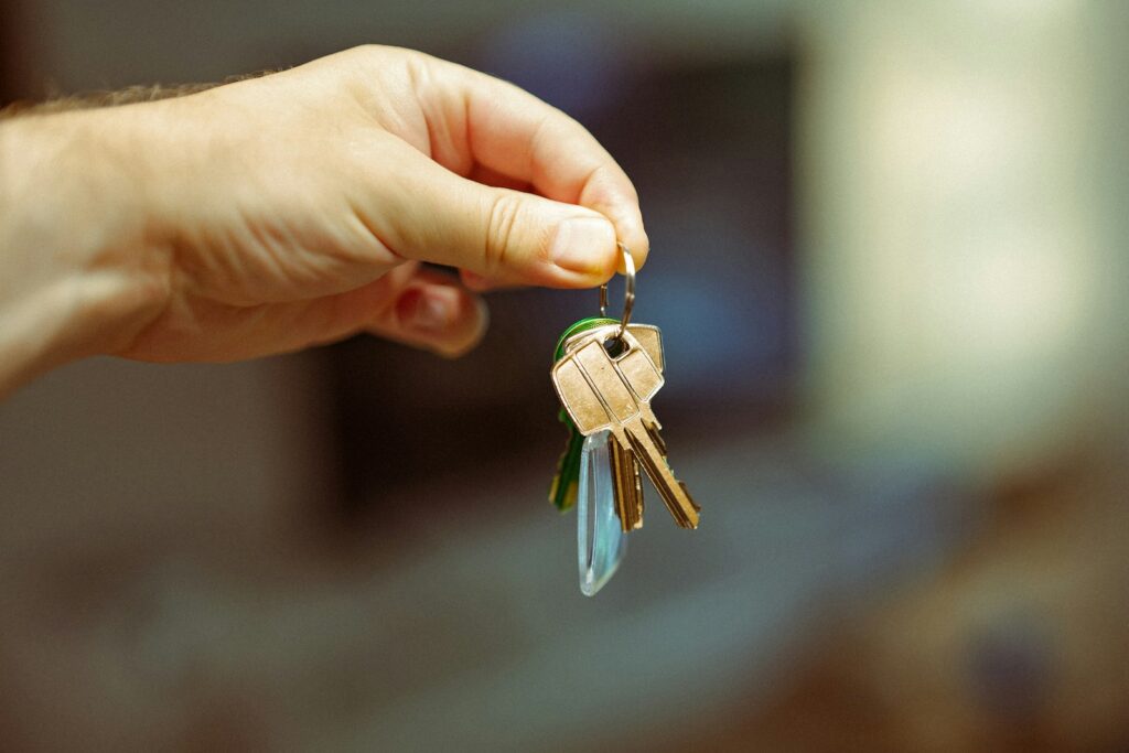 A hand holding a bunch of house keys, representing a property sale going ahead
